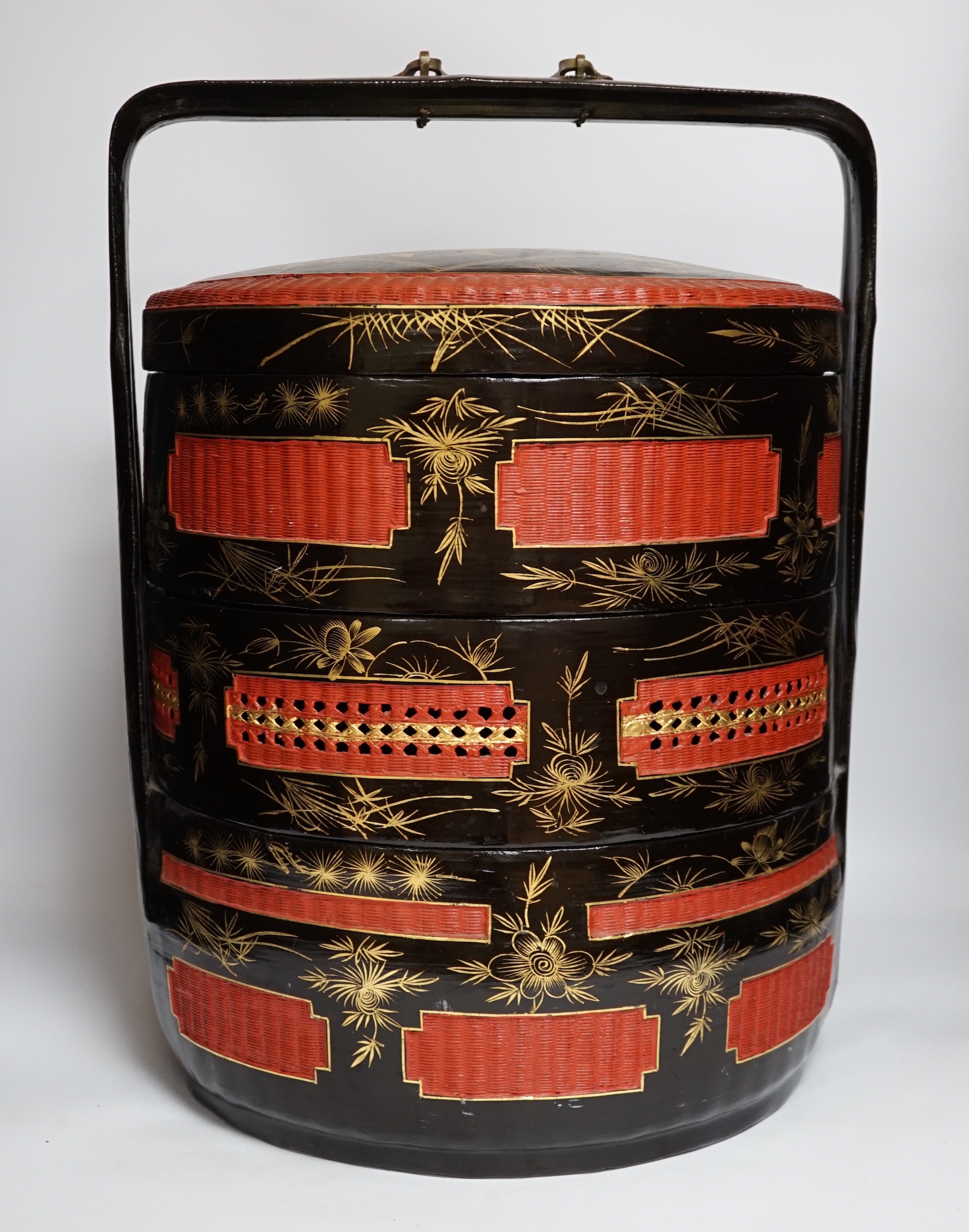 A Chinese three section lacquer wedding basket with gilded decoration